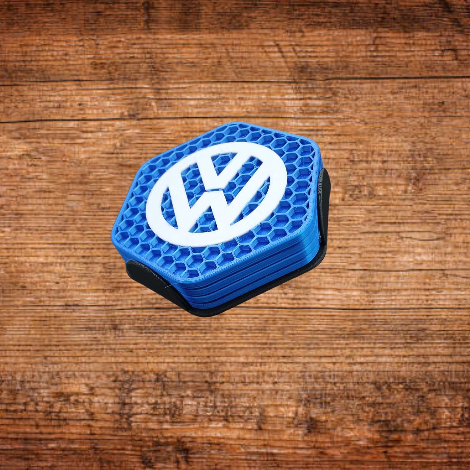 Blauer VW-Untersetzer, sichtbare Stapelhöhe und VW-Logo auf sechseckigem Wabenmuster