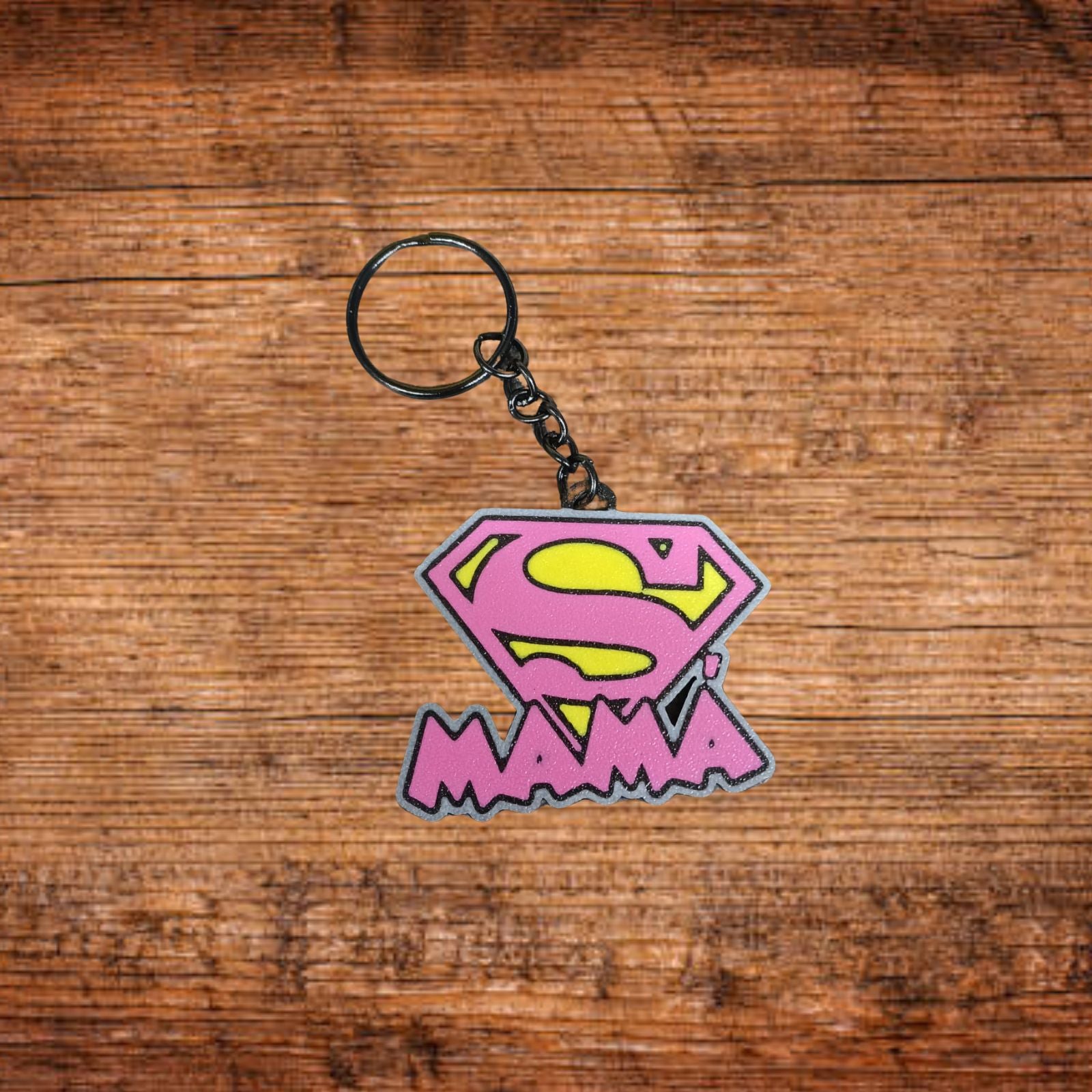 Schlüsselanhänger mit Superman-Logo, lila/pinkem Anhänger und schwarzem Ring.
