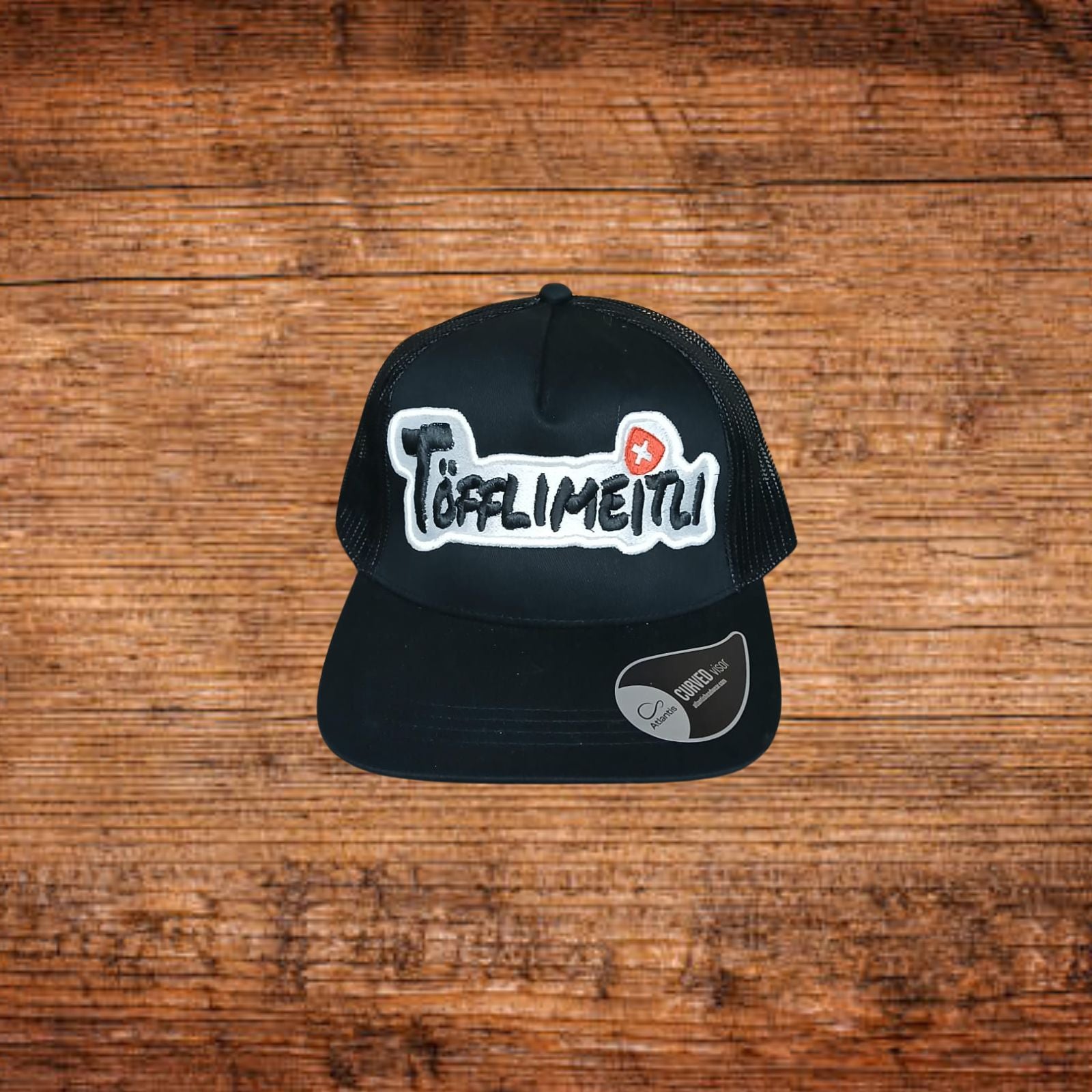 Schwarzes Basecap mit Töfflimeitli-Sticklogo und Netzrückseite
