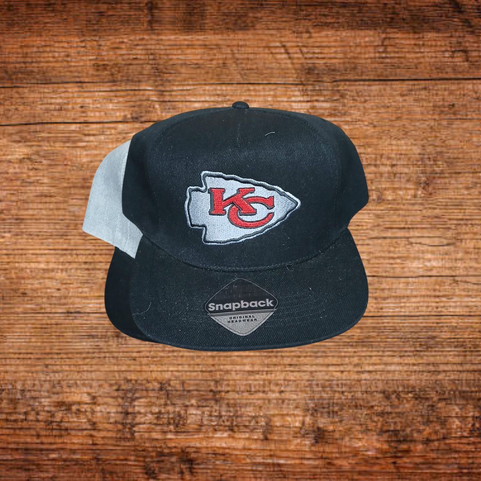 Schwarze Snapback-Cap mit KC-Logo und Snapback-Aufnäher vorn