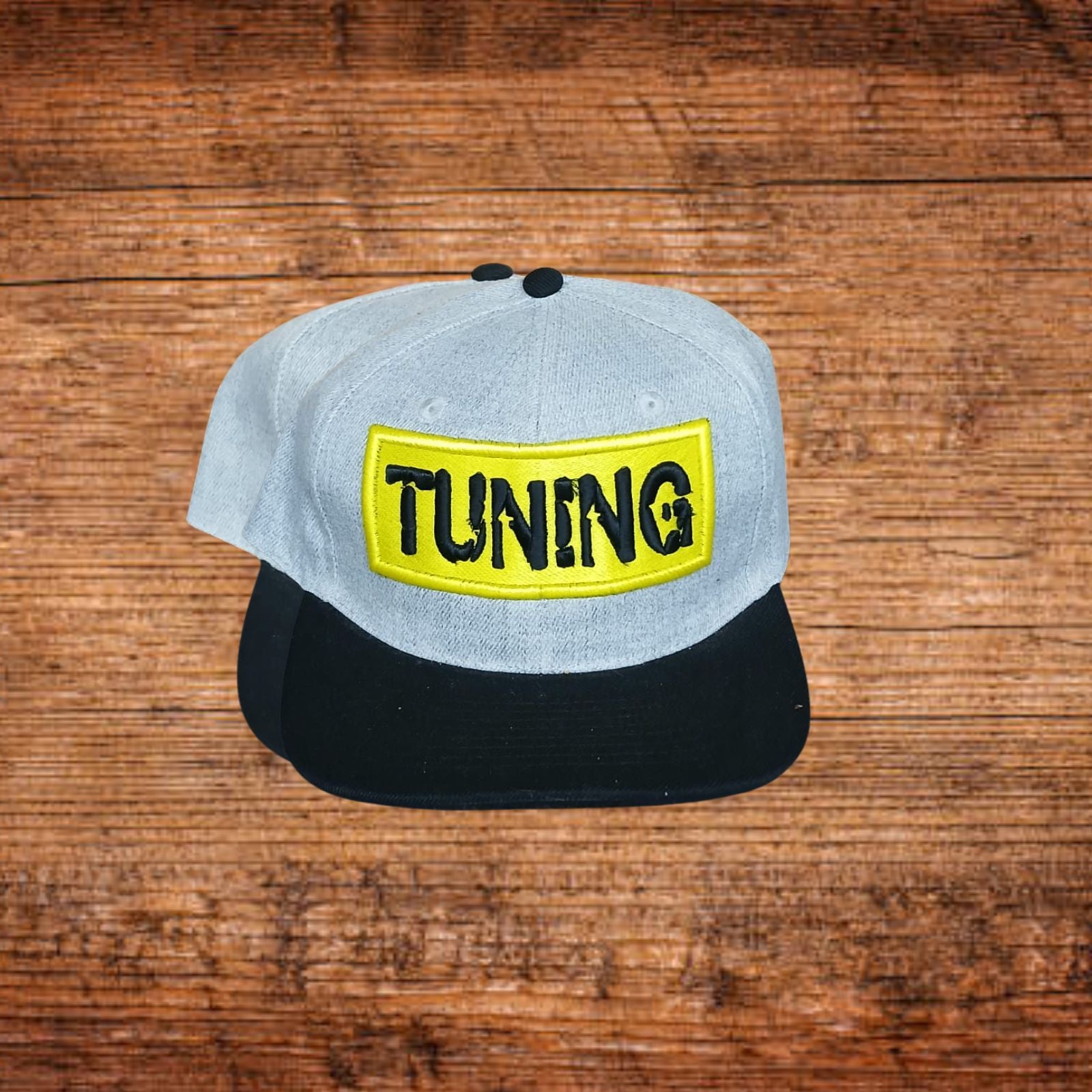 Snapback-Cap mit hellgrauer Kappe, schwarzem Schirm und gelbem Logo-Patch vorn