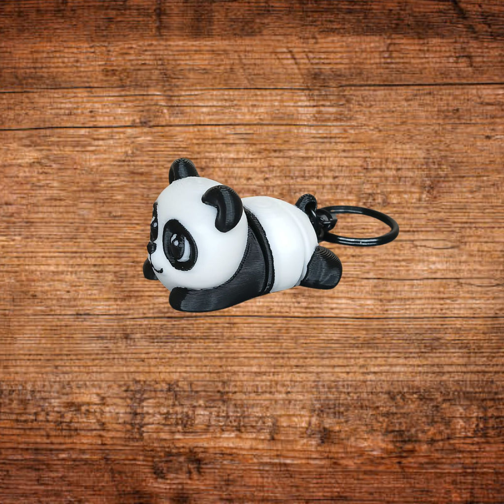Panda-Schlüsselanhänger, liegendes Stofftier mit schwarzen Ohren und Öse am Ring