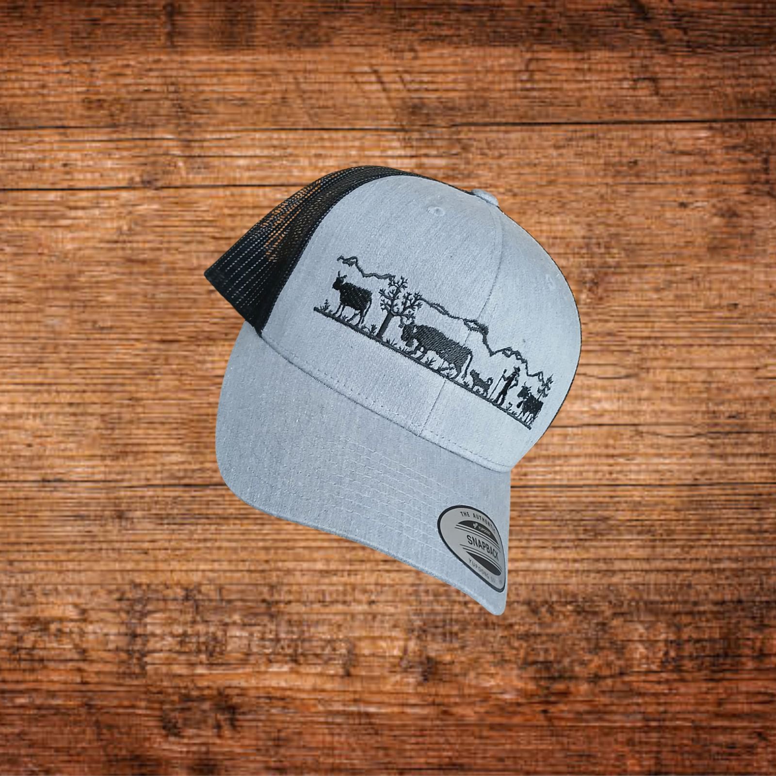 Snapback-Cap grau mit schwarzem Mesh, Seitenansicht mit Alpenlandschaft-Motiv auf dem Band