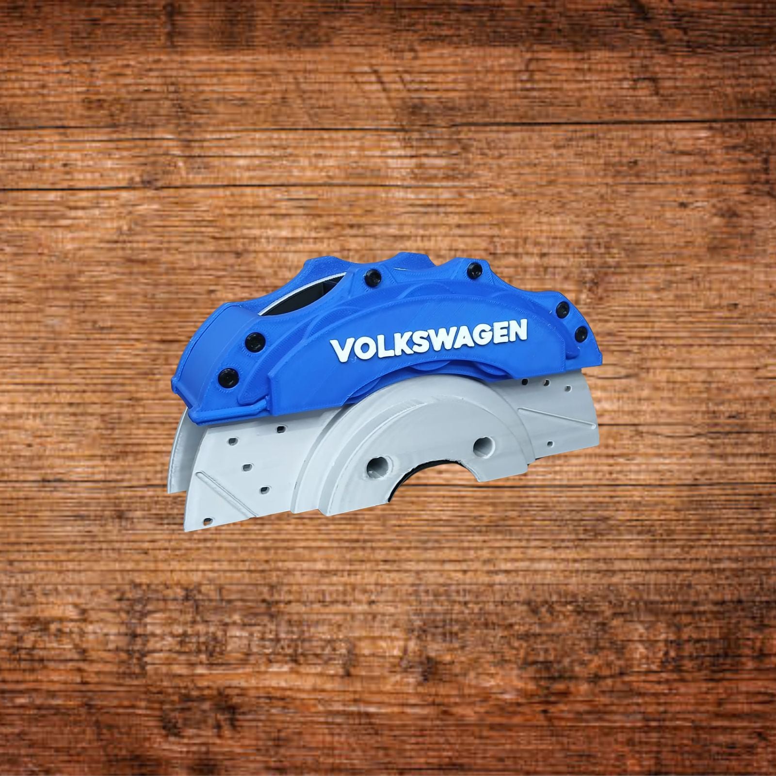 Blauer Bremssattel mit VOLKSWAGEN-Schriftzug auf grauer Grundplatte