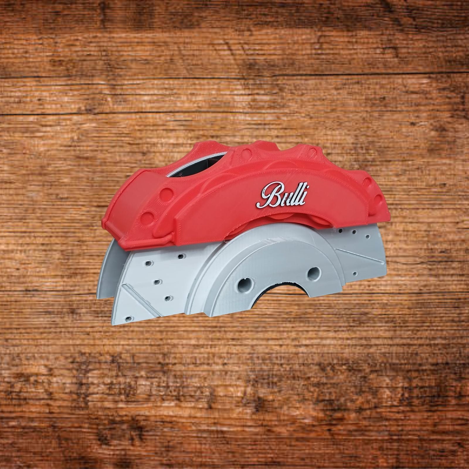 Roter Bremssattel mit Bulli-Logo auf grauer Grundplatte