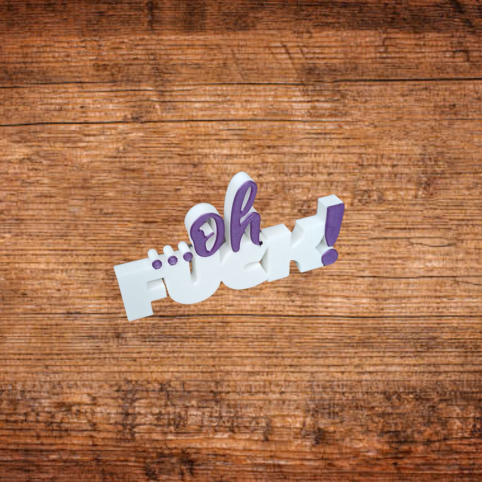 Tischaufsteller aus 3D-Druck mit weißem Schriftzug „F*ck“ und lila Elementen