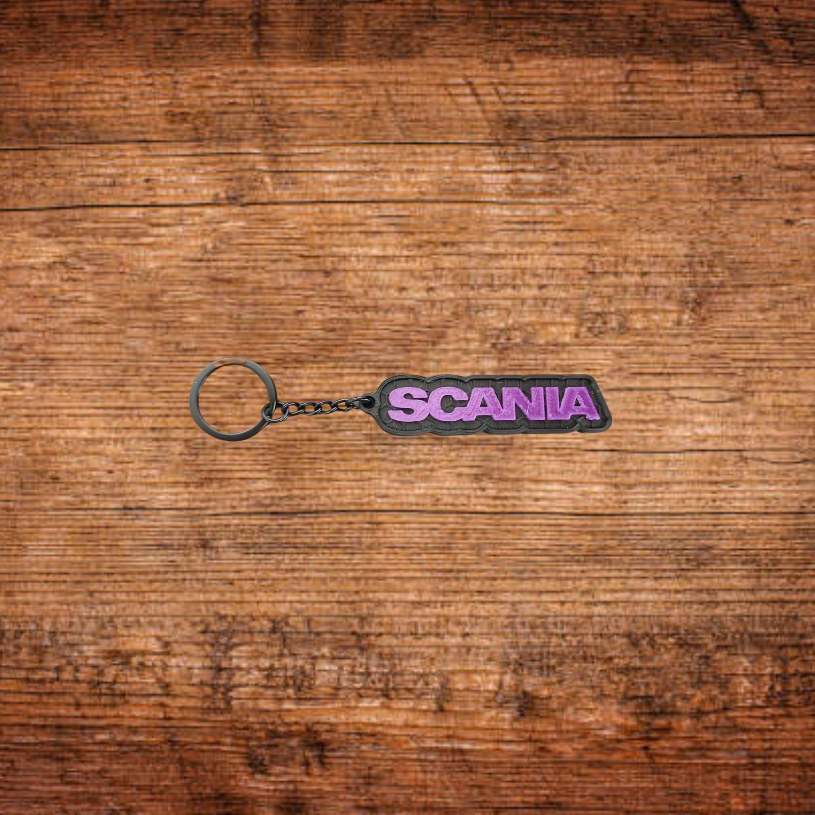 Schlüsselanhänger mit SCANIA-Schriftzug, lila Emblem und silberner Öse