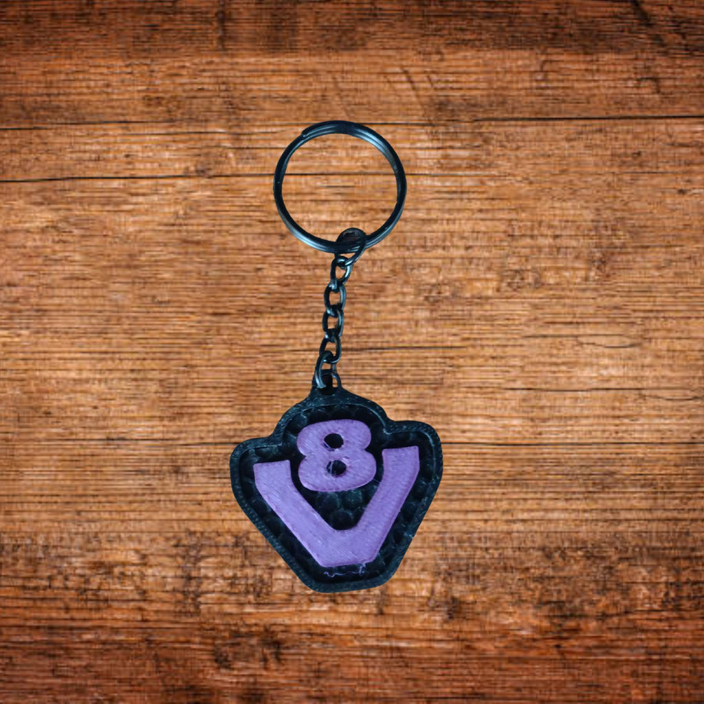 Scania V8 Schlüsselanhänger, dunkler Anhänger mit violettem Rand, Kette und Ring