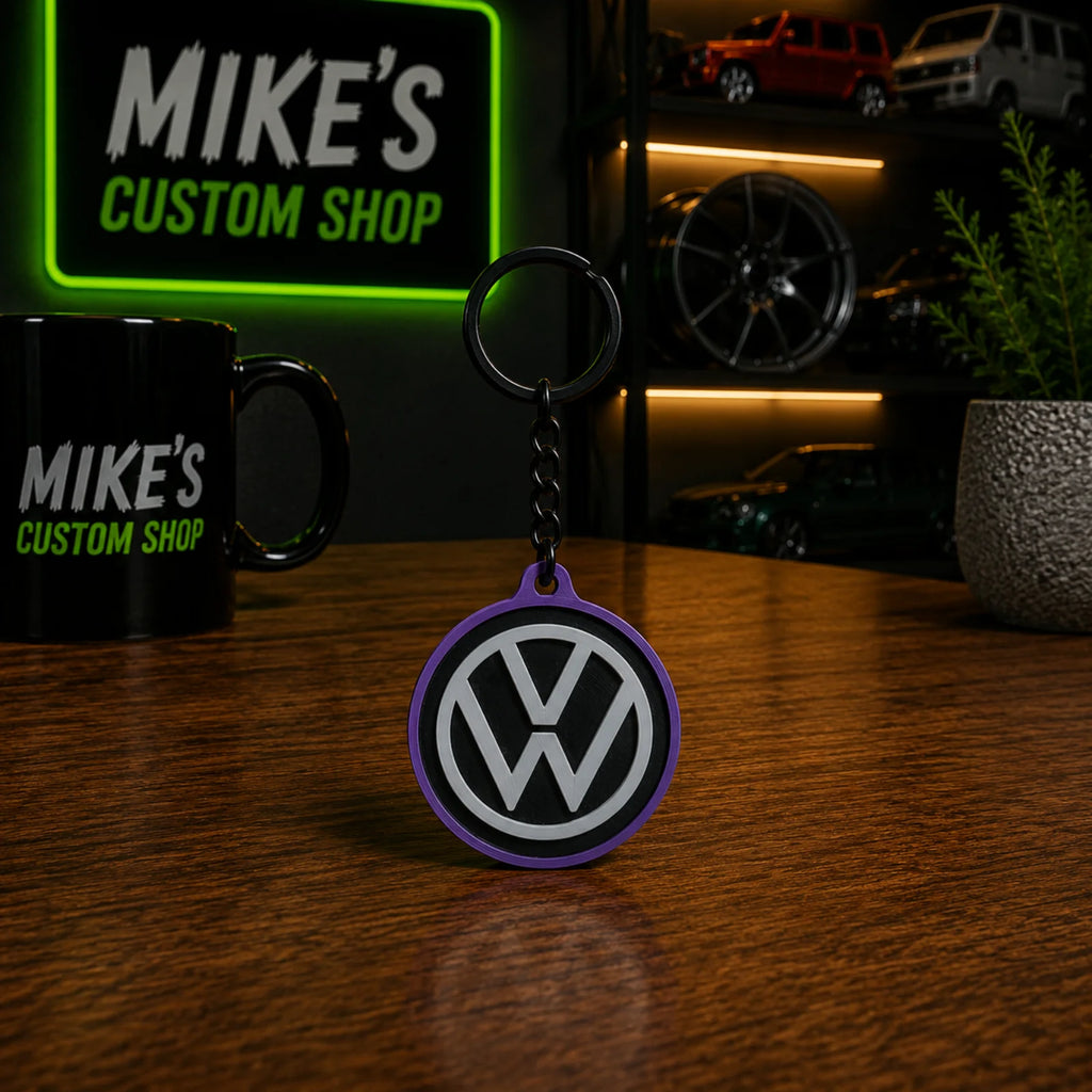 VW Schlüsselanhänger, runder lila Anhänger mit VW-Logo am schwarzen Ring
